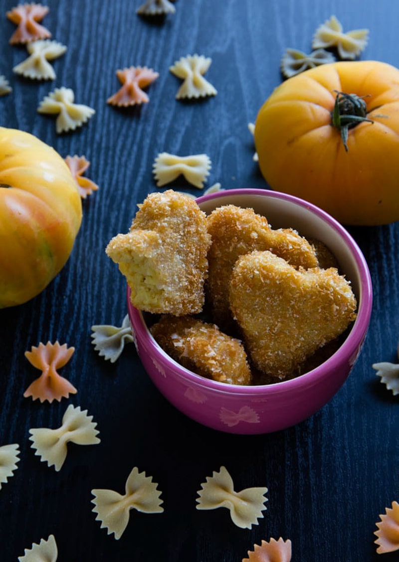 heart-shaped fried mac and cheese resting in a pink bowl.