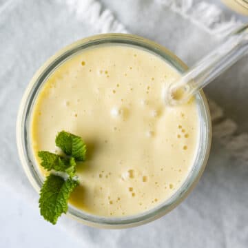 overhead shot of mango smoothie in a jar garnished with mint