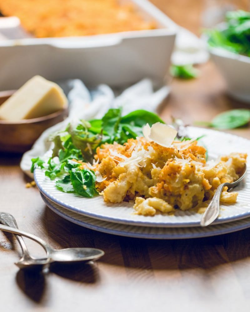 a serving of macaroni and cheese on a plate with a side salad.