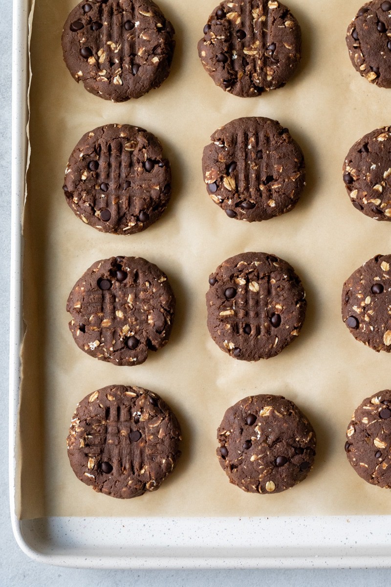 protein cookies up on a parchment lined baking sheet ready to be baked.