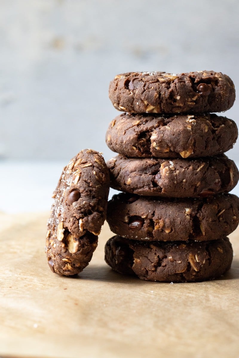 a stack of chocolate protein cookies against a gray background.