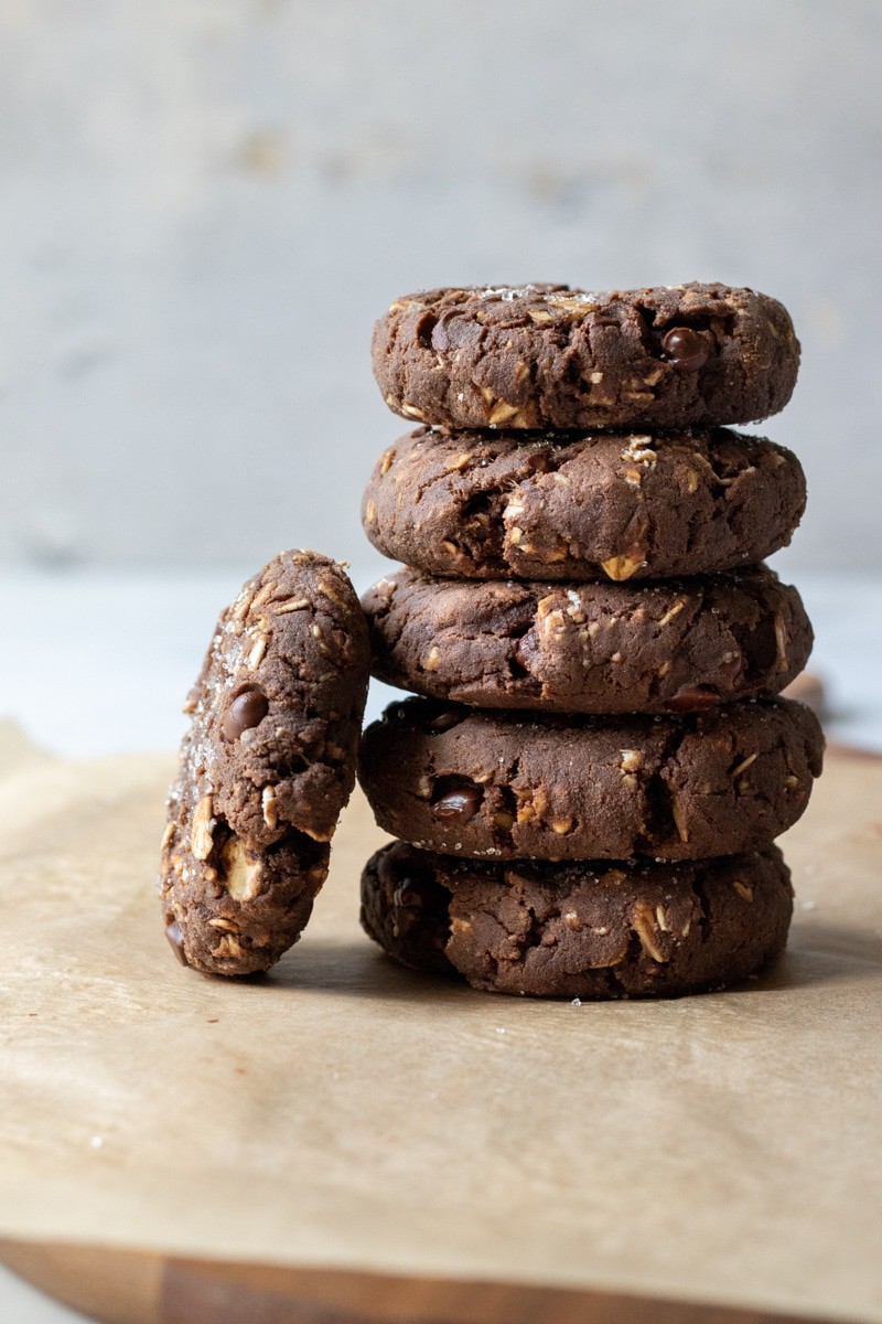 a stack of chocolate protein cookies on parchment paper.
