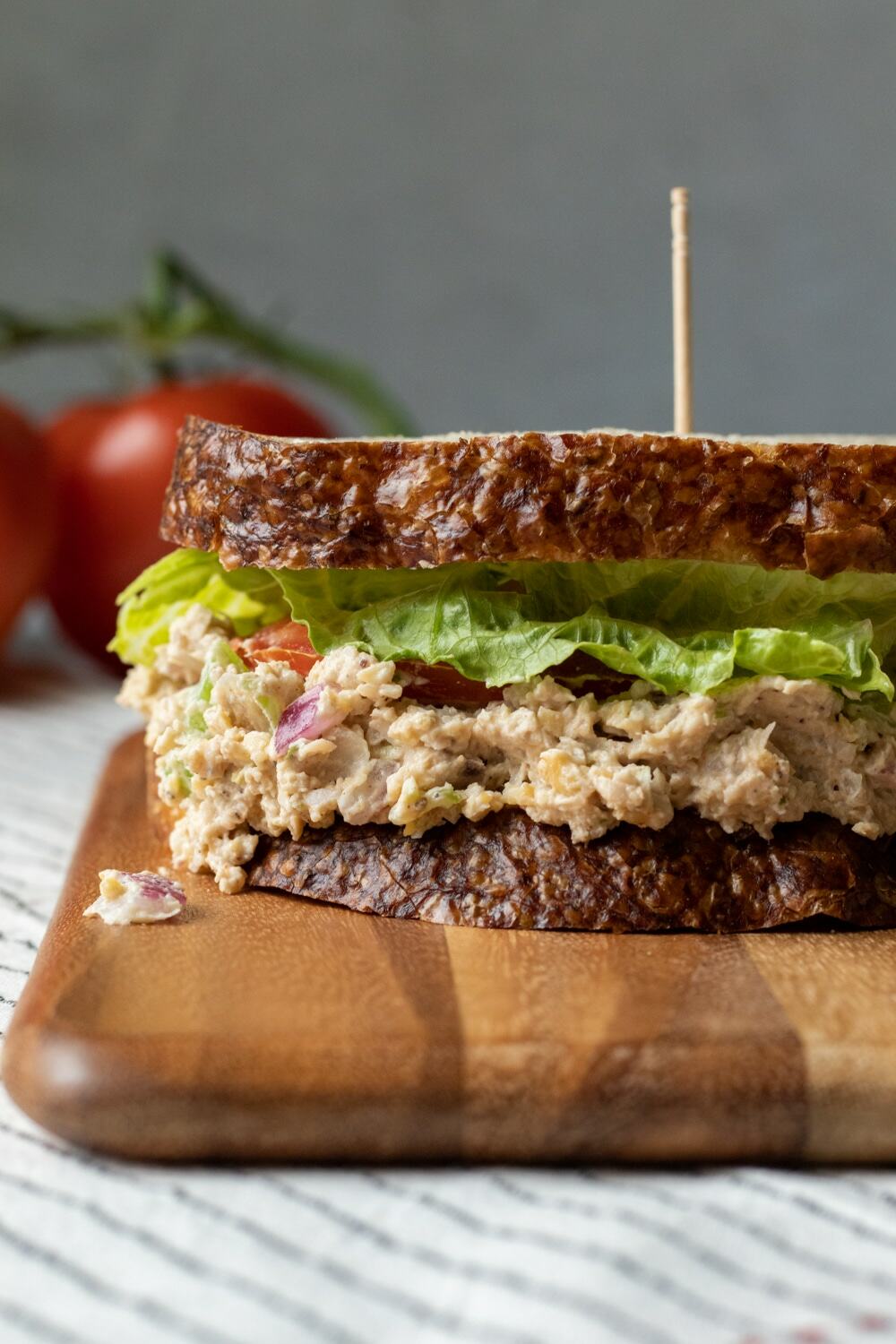 side view of vegan tuna salad sandwich, made with chickpeas and jackfruit, red onion, celery.