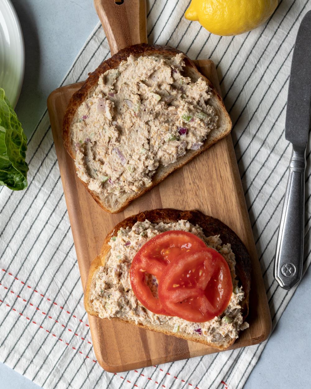 overhead photo of chickpea-jackfruit tuna salad on toasted bread with sliced tomato.