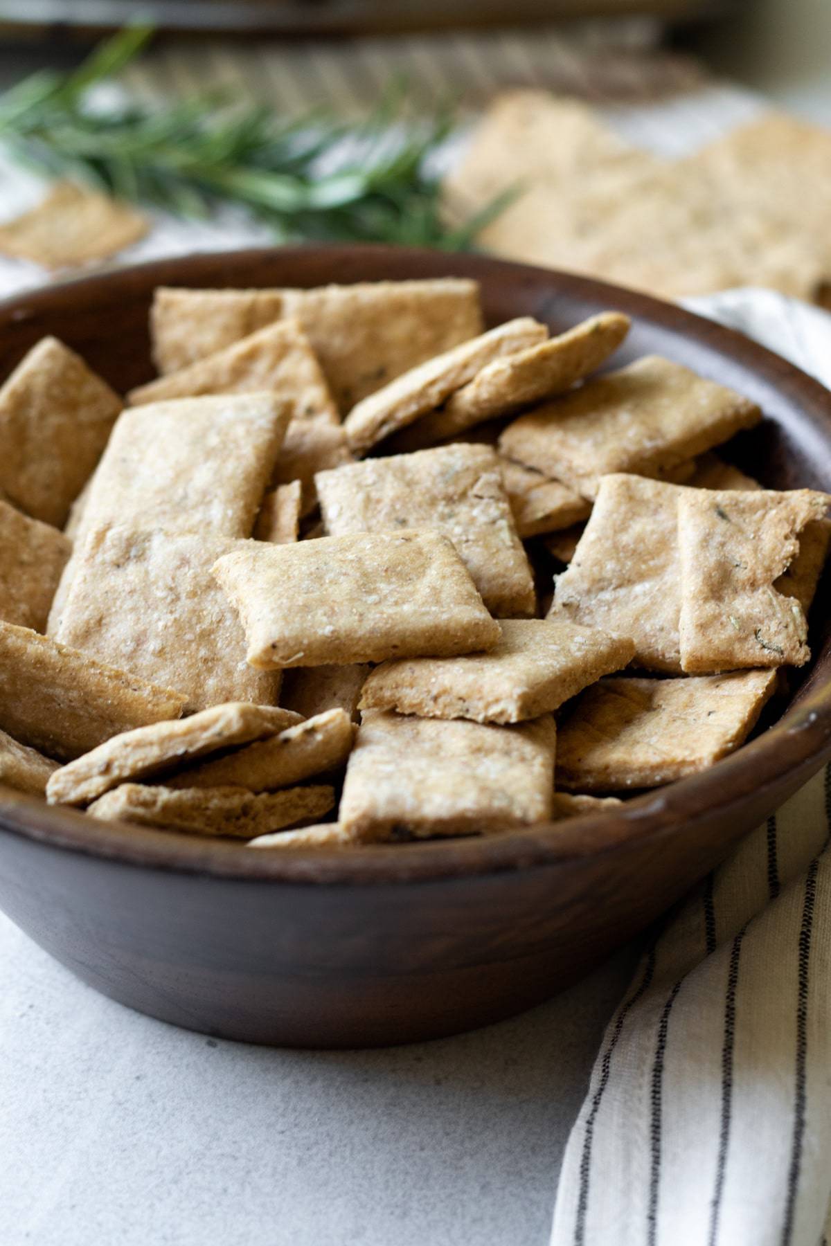 rectangular wheat crackers in a wooden bowl.