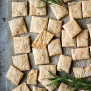 crackers and sprigs of rosemary on a baking sheet