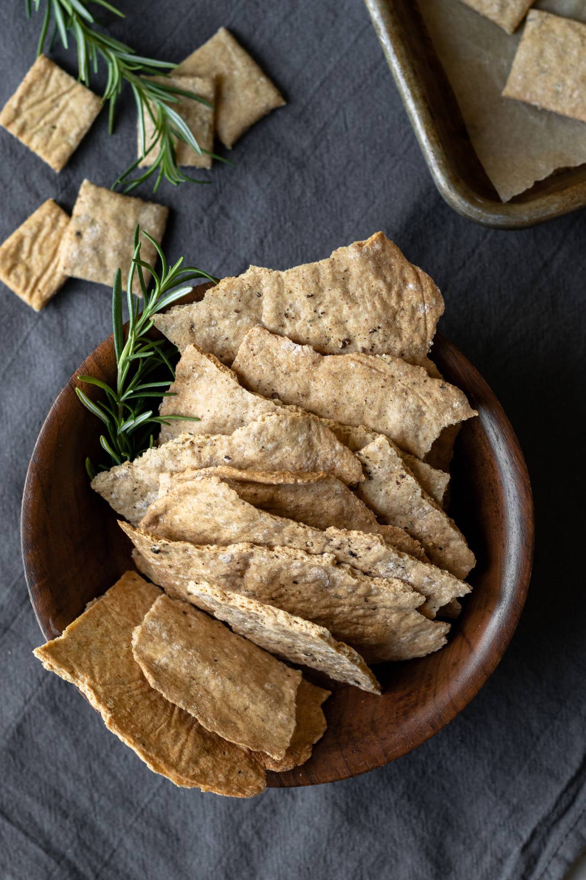 artisan whole wheat crackers in a wooden bowl.