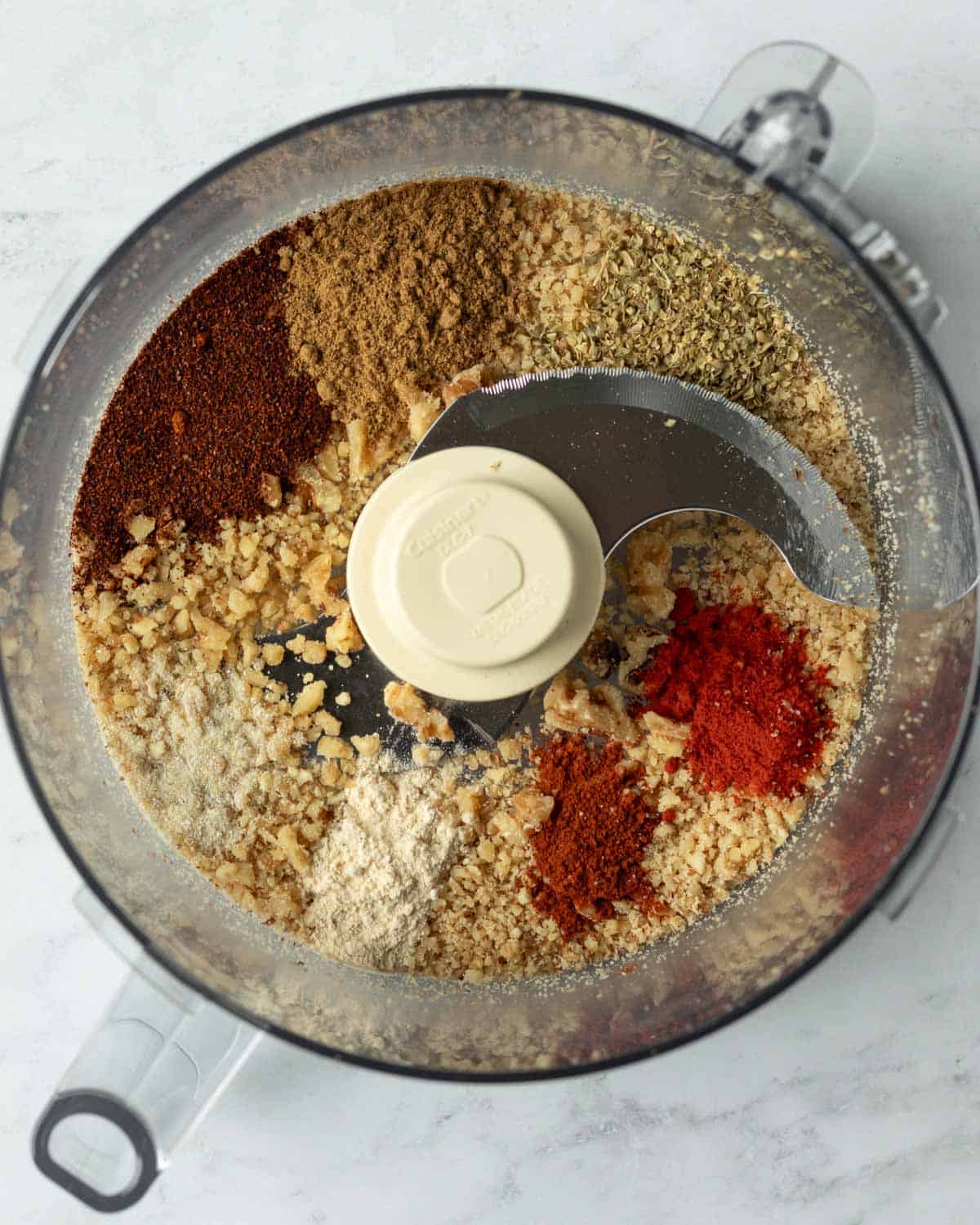 overhead view of walnuts and spices in food processor.