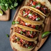 colorful vegan soy tacos lined up on a cutting board.