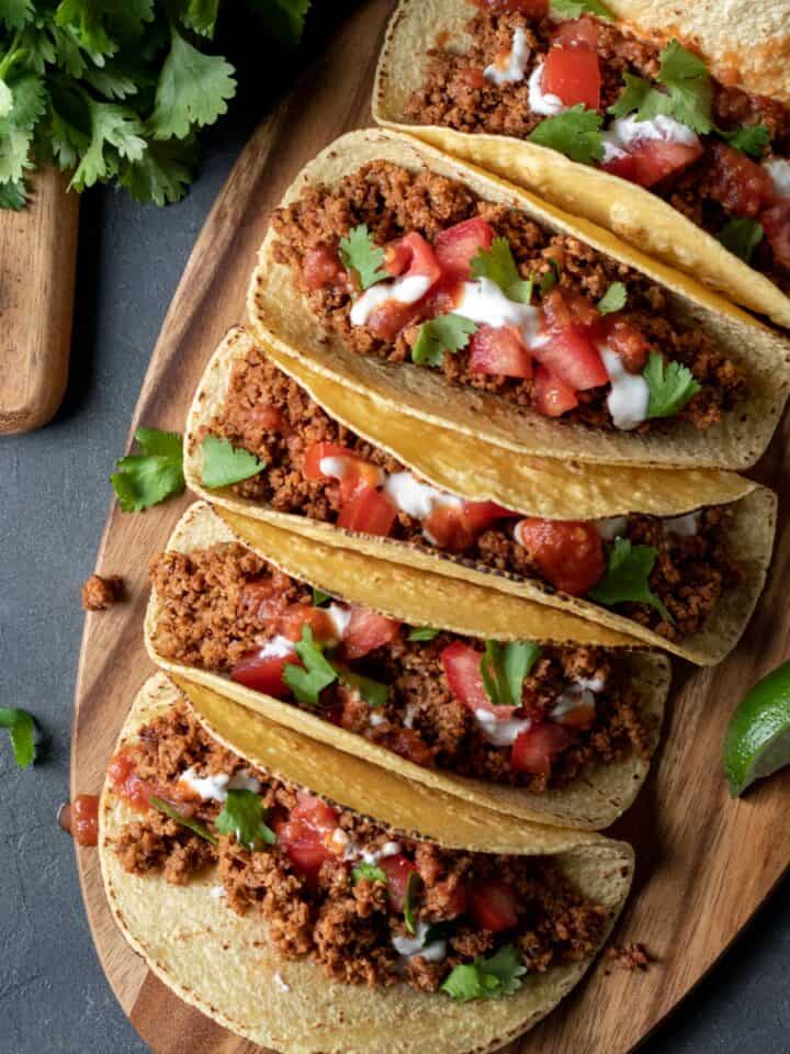colorful vegan soy tacos lined up on a cutting board.