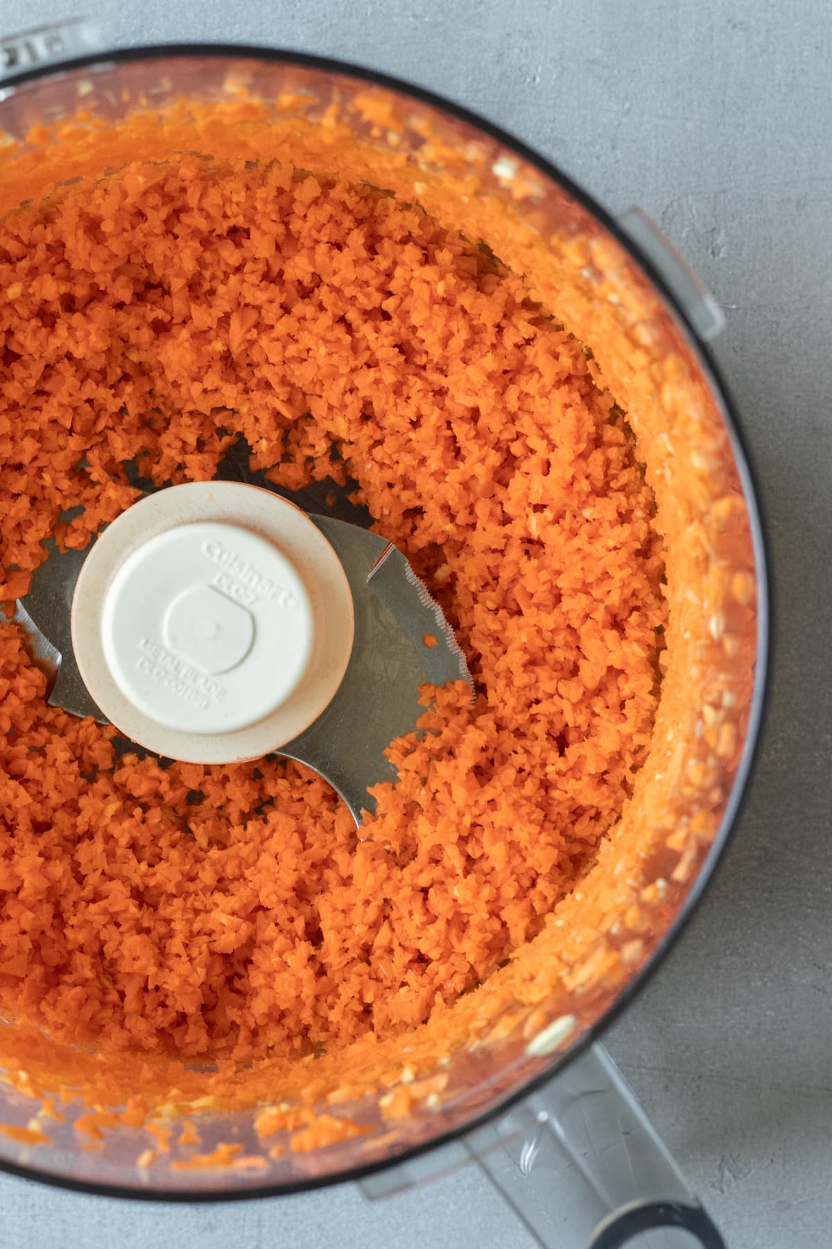 view of carrots chopped up inside food processor.