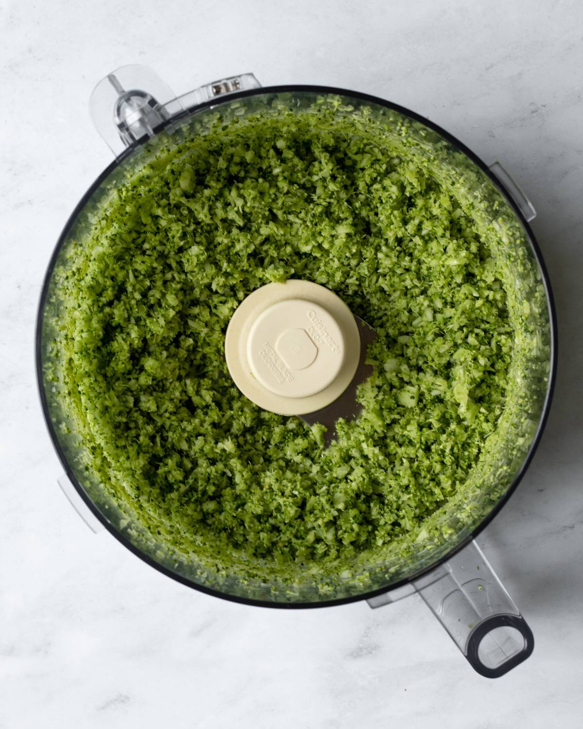 after processing, view of riced broccoli inside food processor.