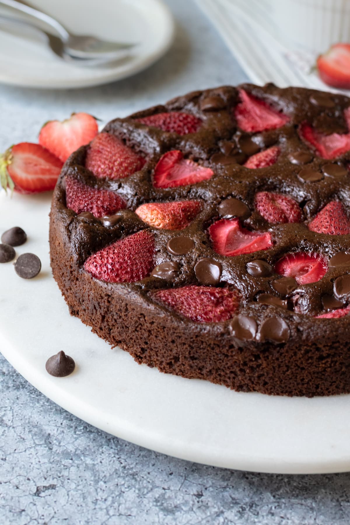 strawberry chocolate chip topped cake on a cake stand