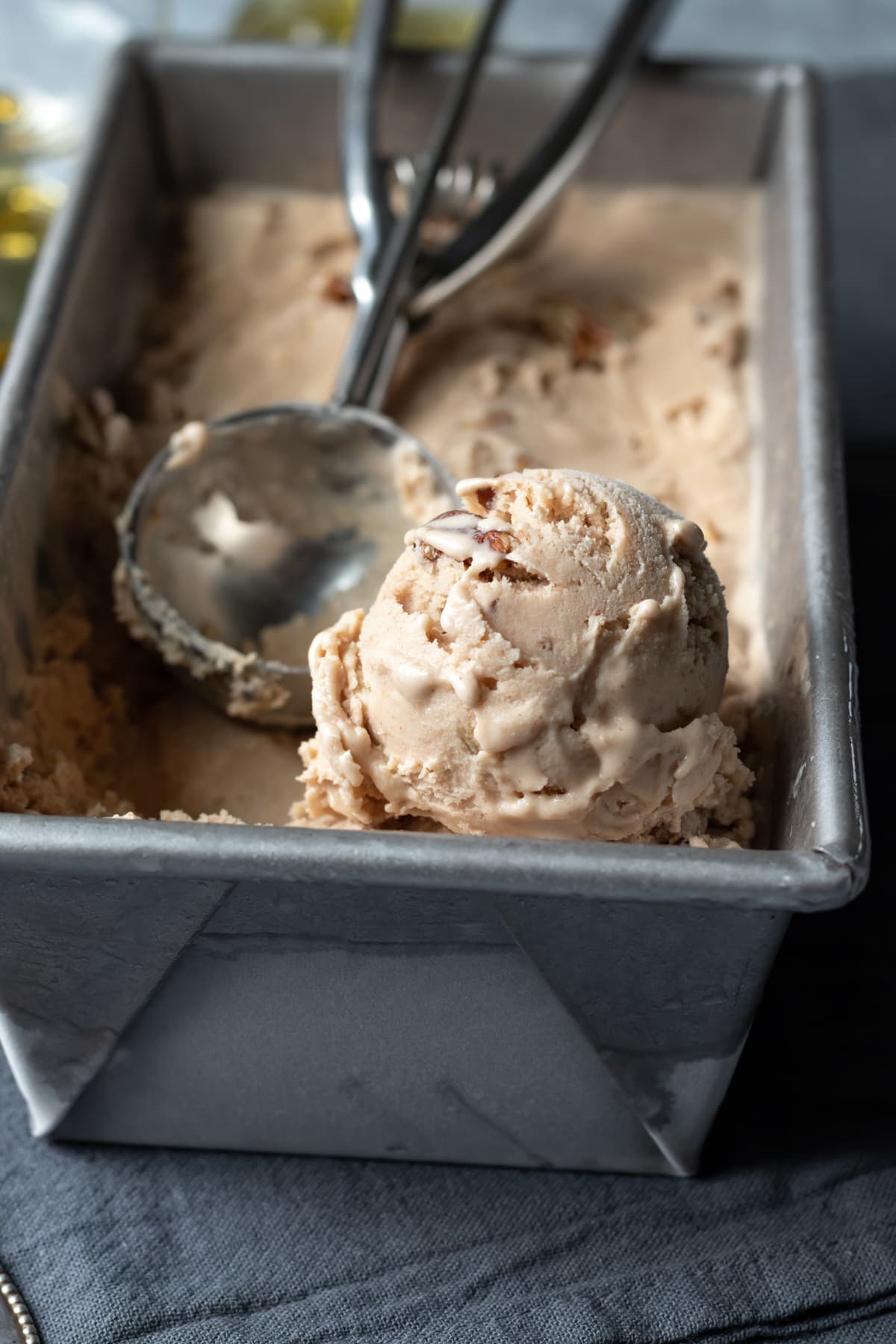 a scoop of butter pecan in a metal loaf pan