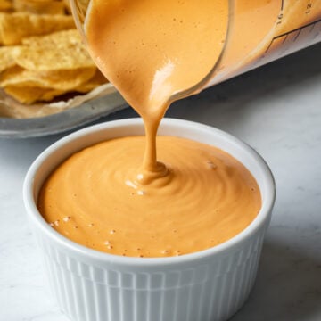 close up shot of pouring creamy cashew cheese sauce