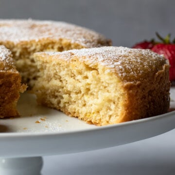 side view of a slice pulled away from rest of cake on a cake stand