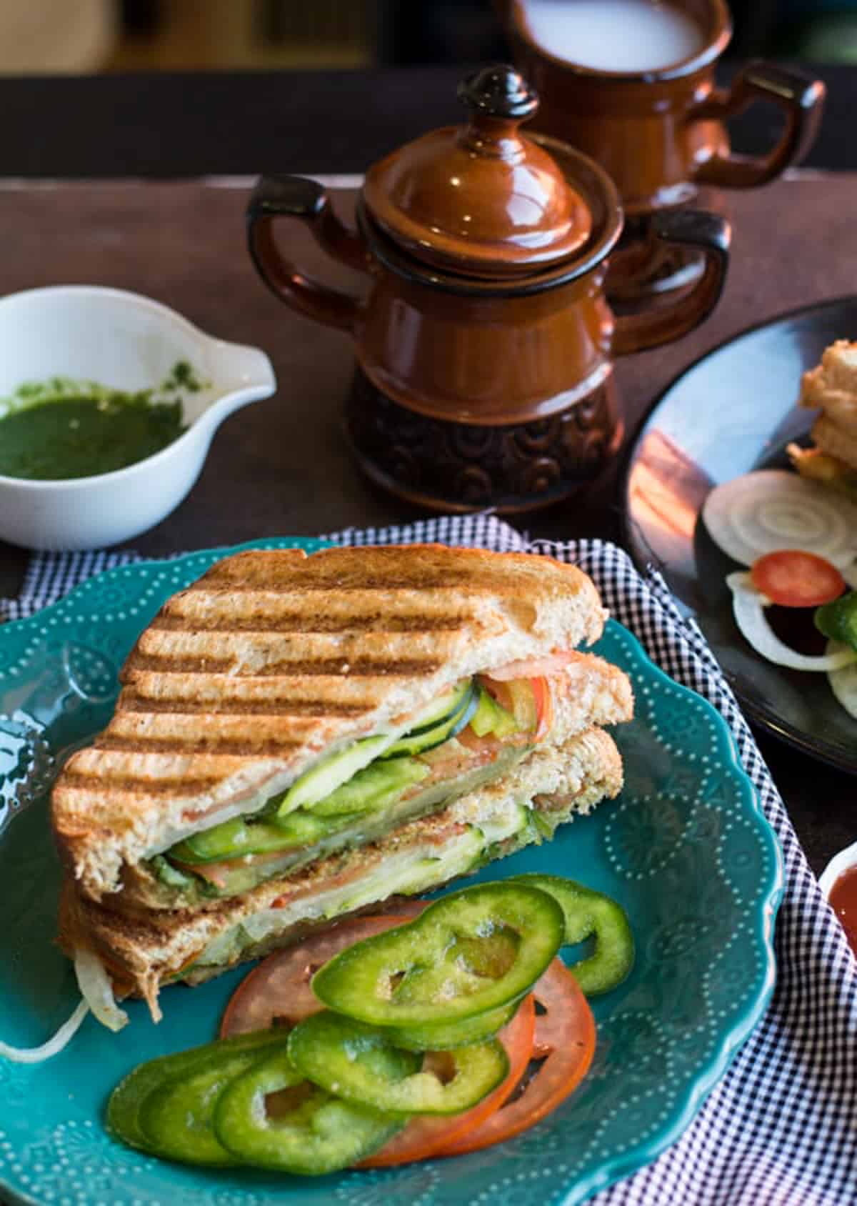 a table setting with sandwich on a turquoise plate.