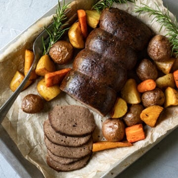 overhead of seitan roast and veggies on a platter.