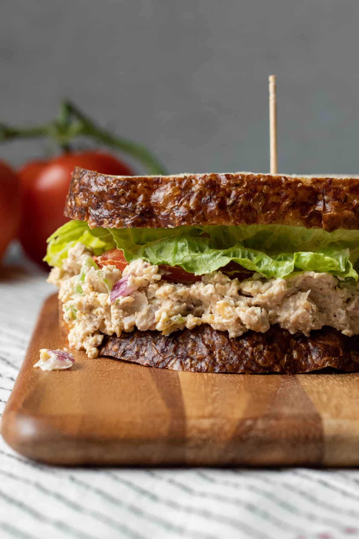 close up side shot of a vegan tuna salad sandwich with lettuce and tomato.