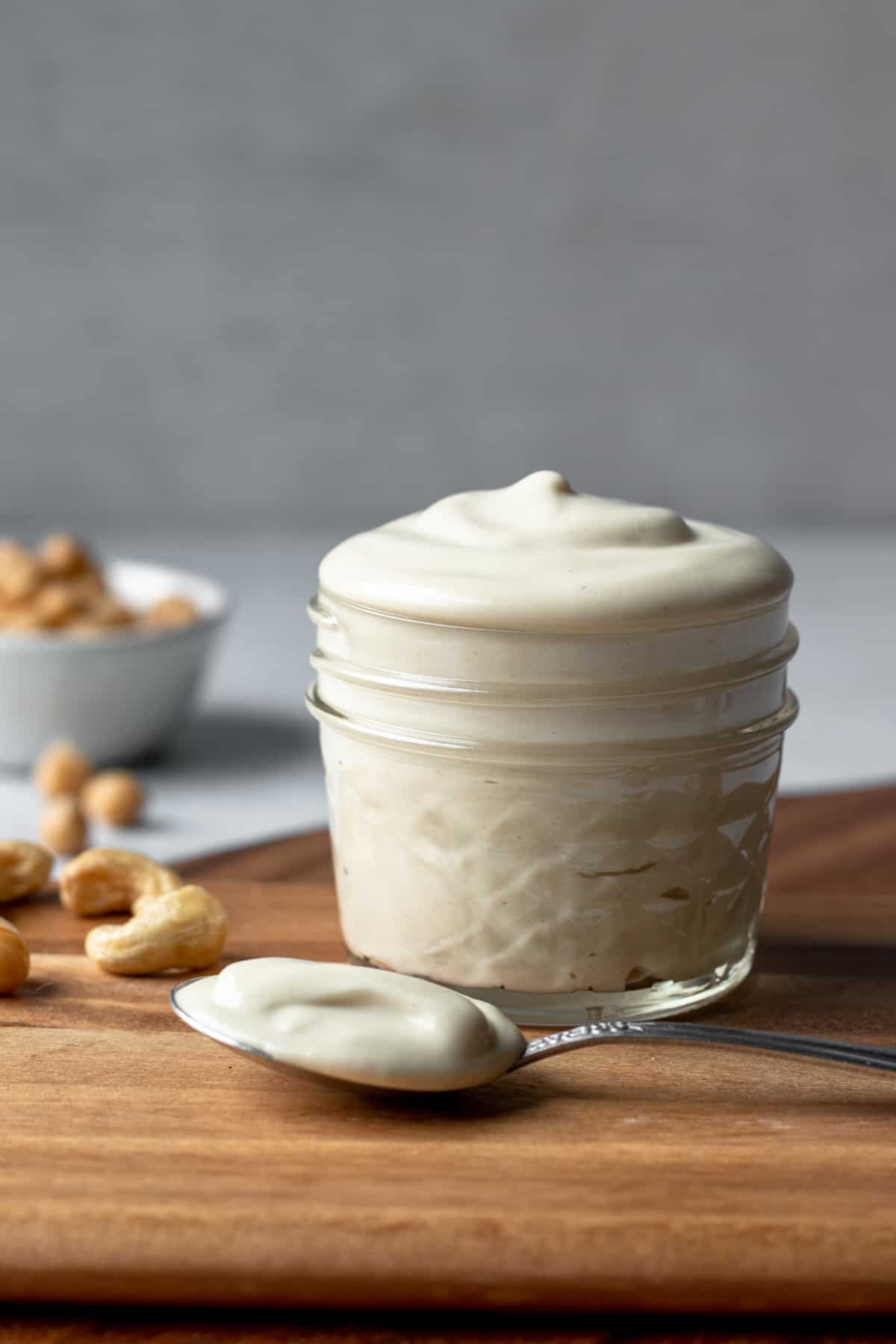 vegan mayo in a small jar on a wooden board.