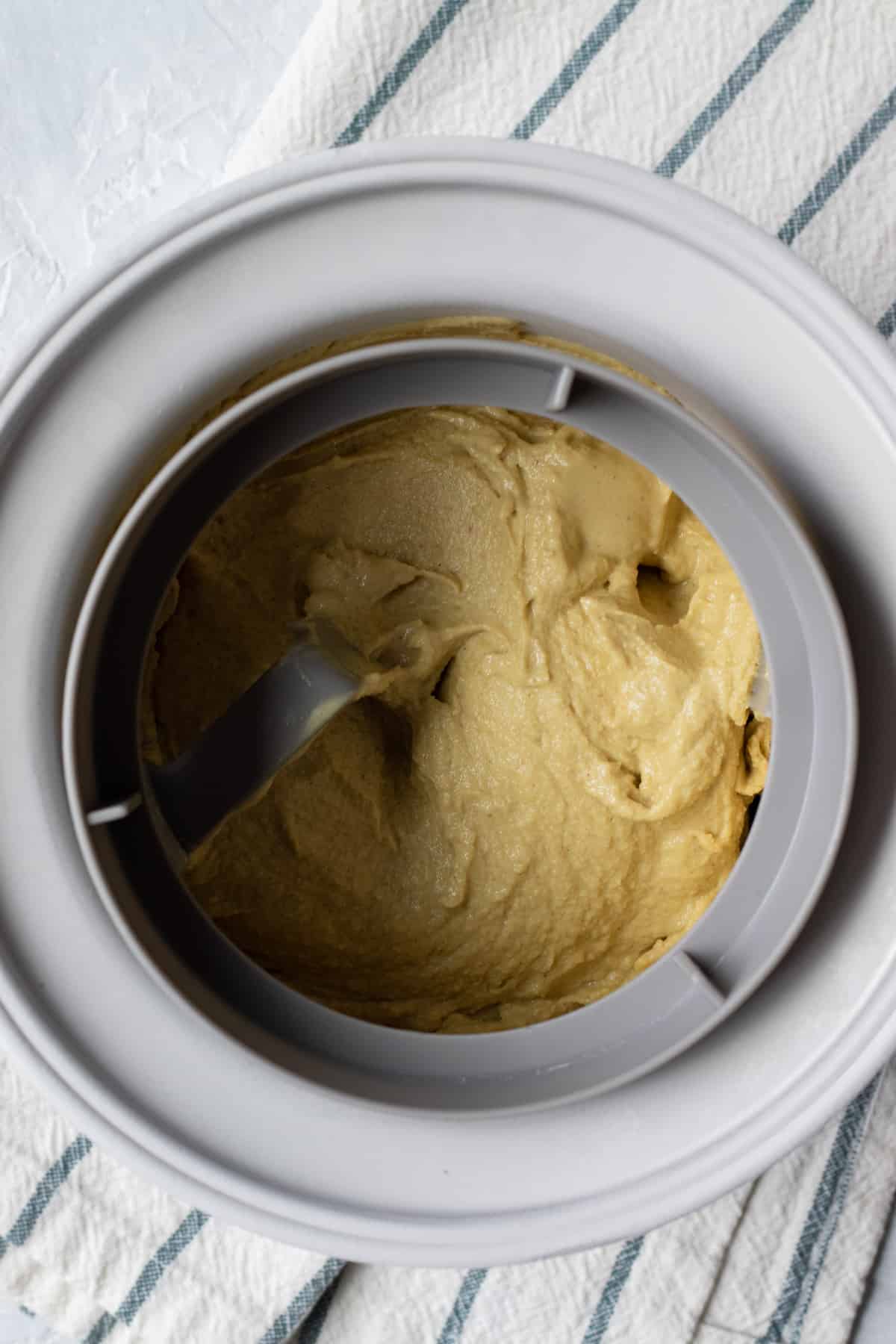 looking into the ice cream maker canister and showing a thick, soft-serve consistency.
