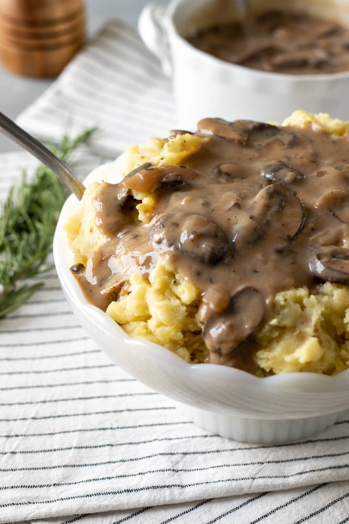 close up showing gravy running down the side of some vegan mashed potatoes.
