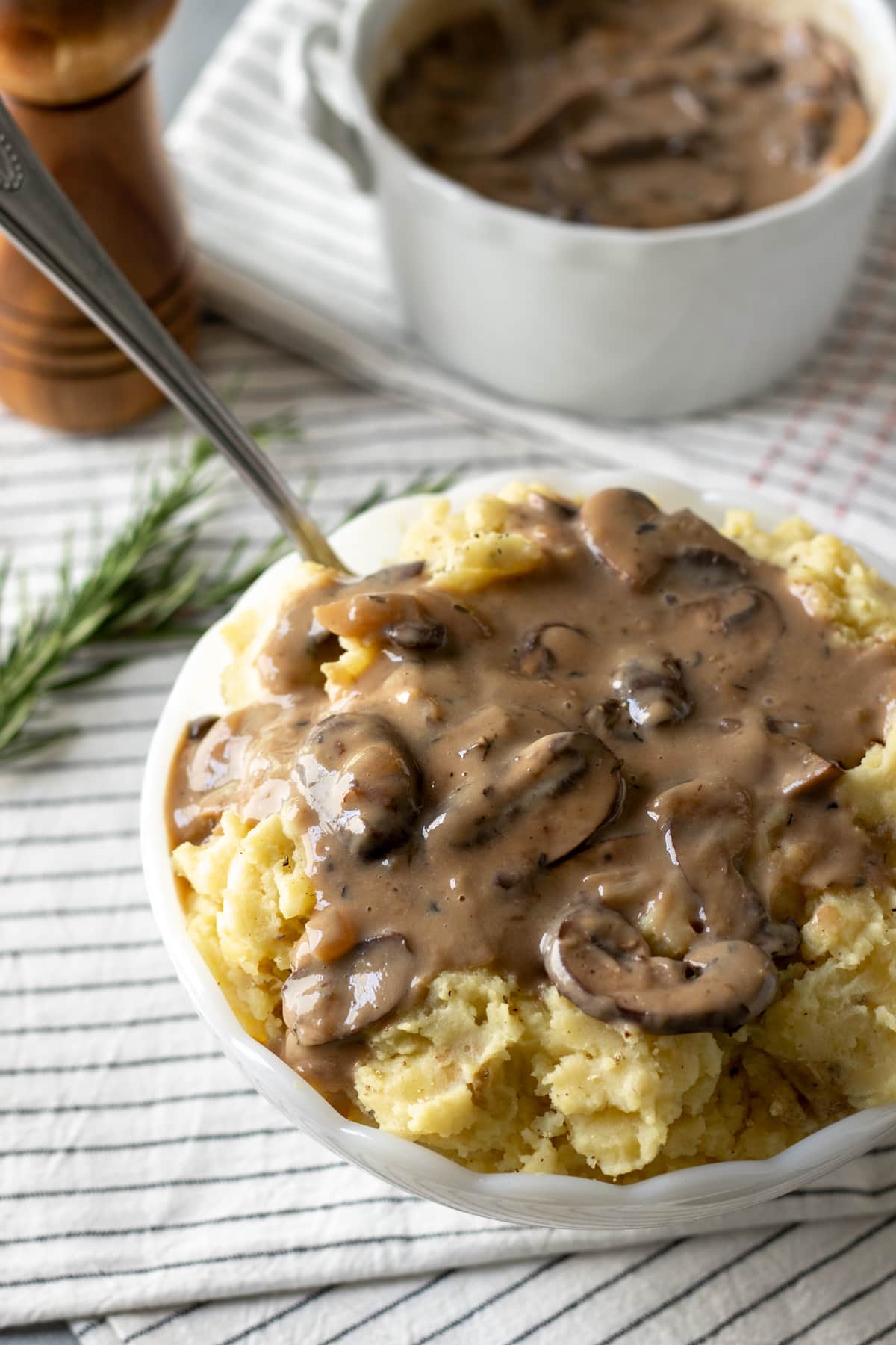 looking down at a bowl full of mashed potatoes topped with mushroom gravy.