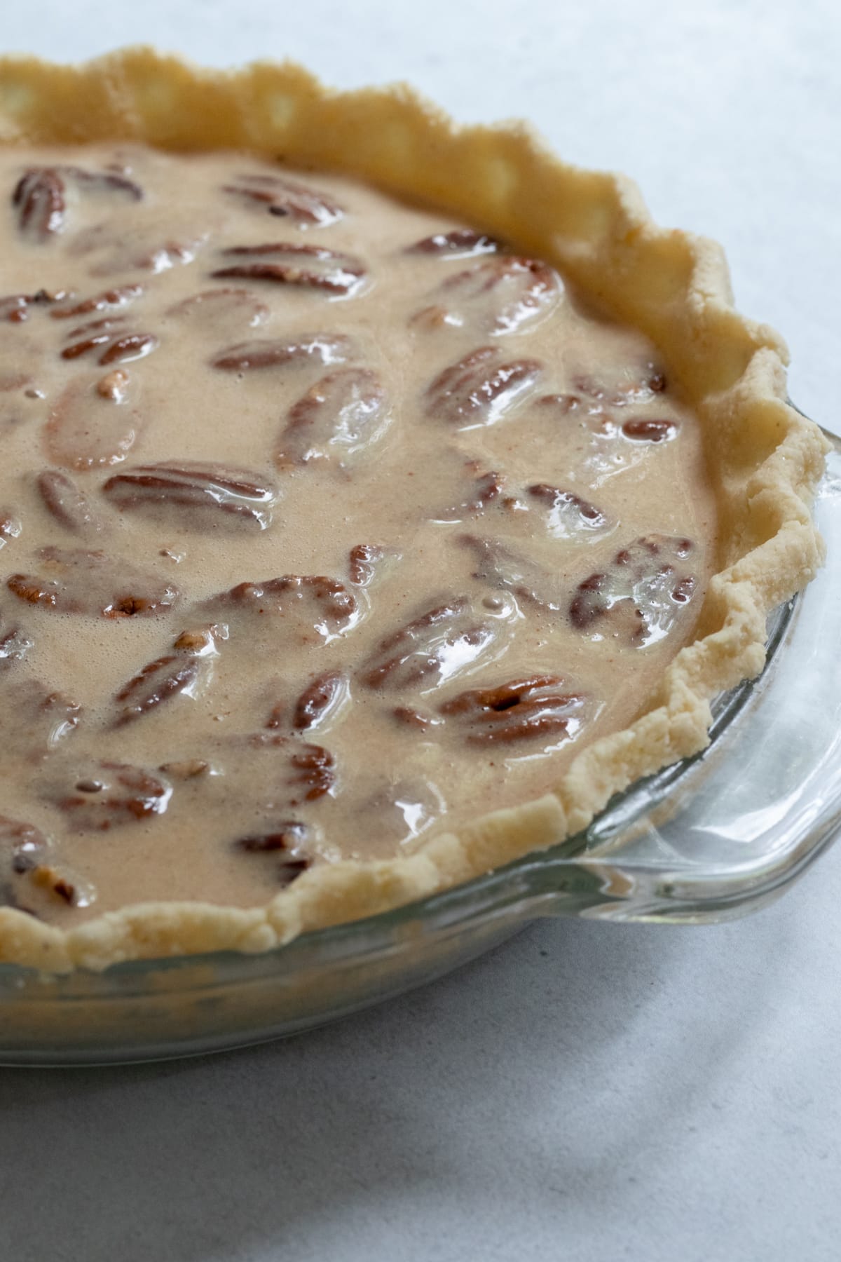 side view of unbaked pecan pie, ready to go into the oven.