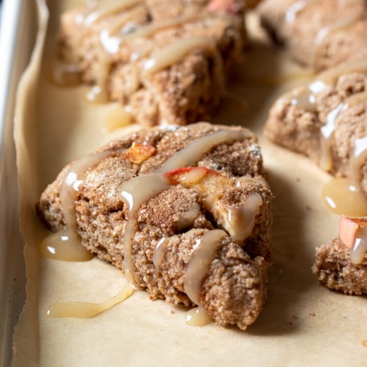 apple cinnamon scones drizzled with maple glaze on a baking pan