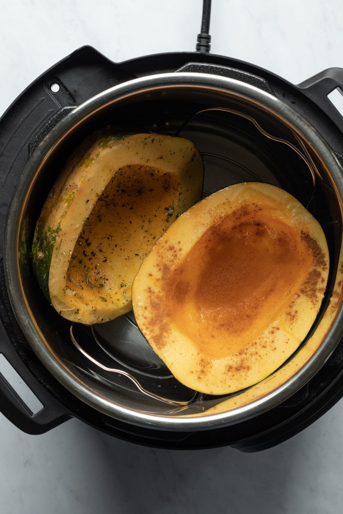 looking into the Instant Pot with two halves of acorn squash.