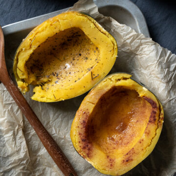 close up of cooked squash, one sprinkled with salt and herbs, one with cinnamon and maple