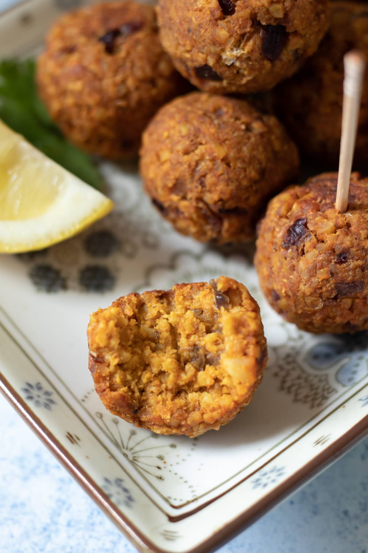 bite taken to show interior texture of spiced vegan meatballs.