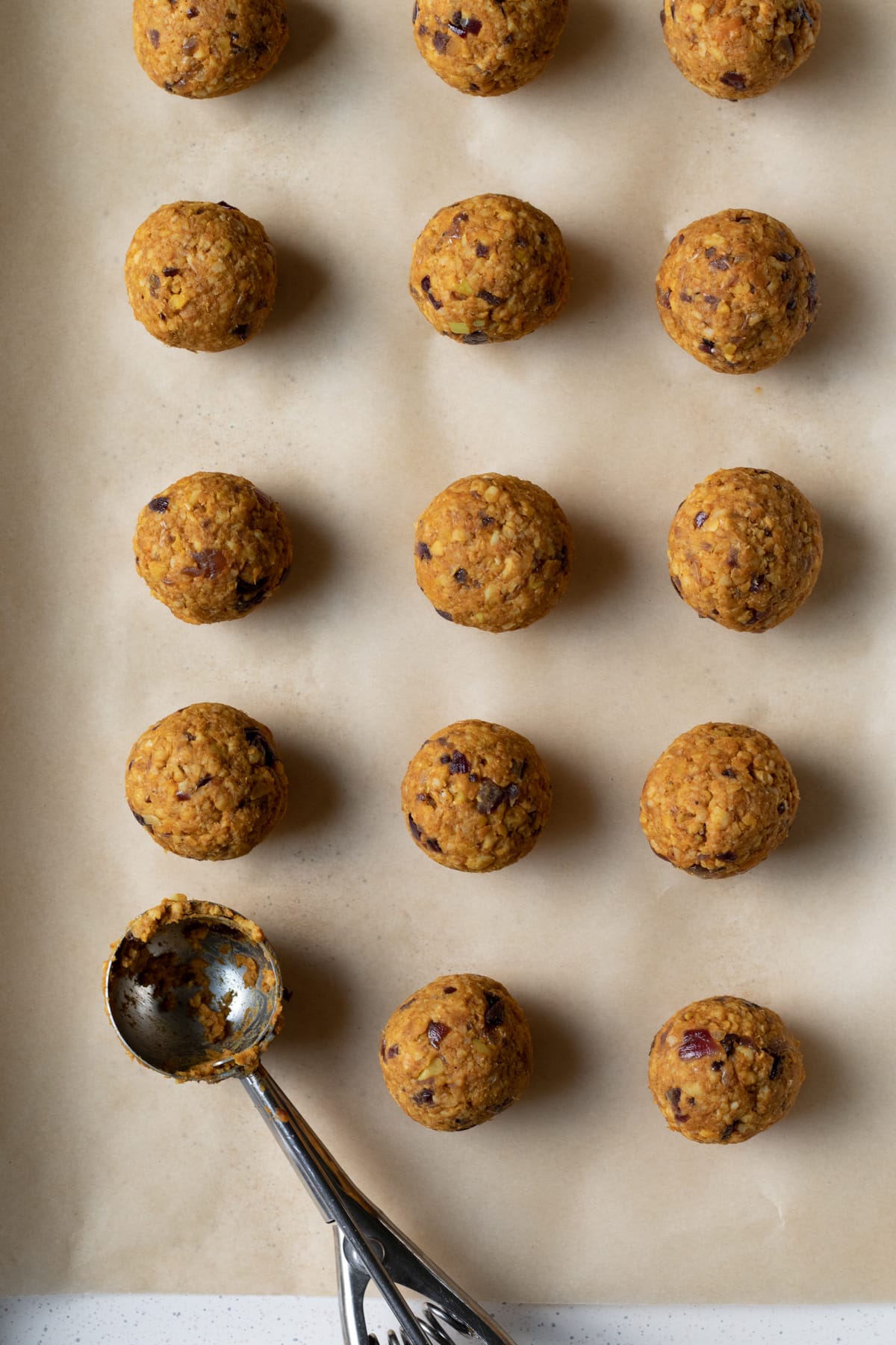 tempeh meatballs lined up on a baking sheet.