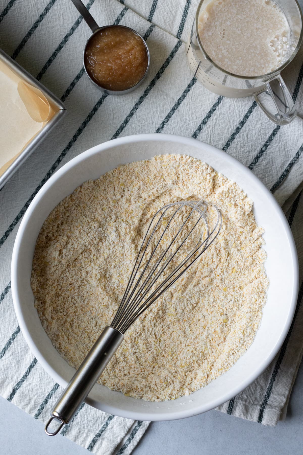 overhead view of mixing dry ingredients in large bowl, wet ingredients separately.