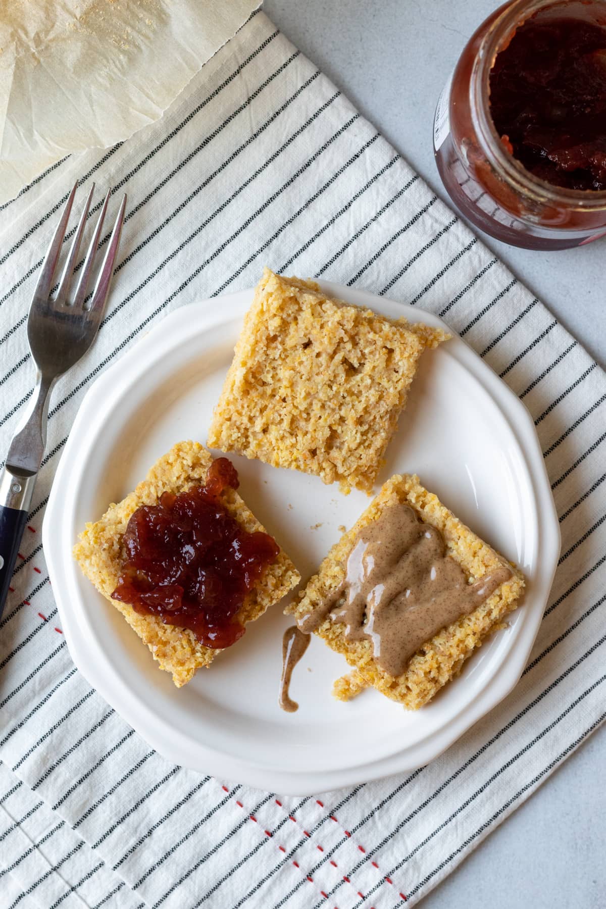 overhead view of sliced open pieces of cornbread topped with almond butter and jelly.