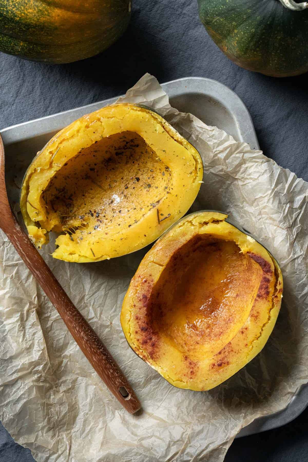 two cooked halves of acorn squash on a platter