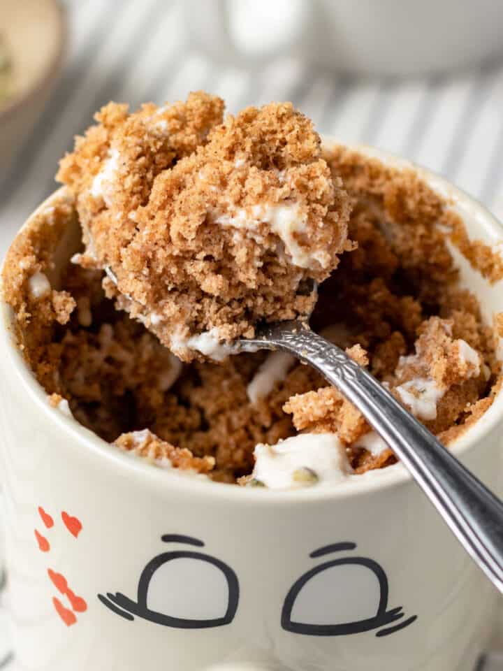 close up of oat flour vegan mug cake in a cute smily face mug.