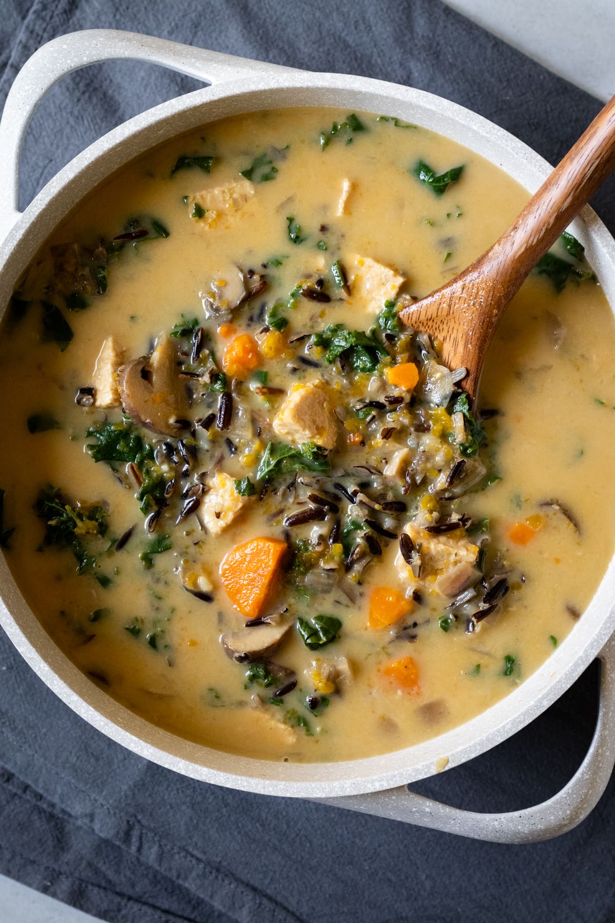 a large pot full of creamy vegan soup with mushrooms, tempeh, and wild rice.