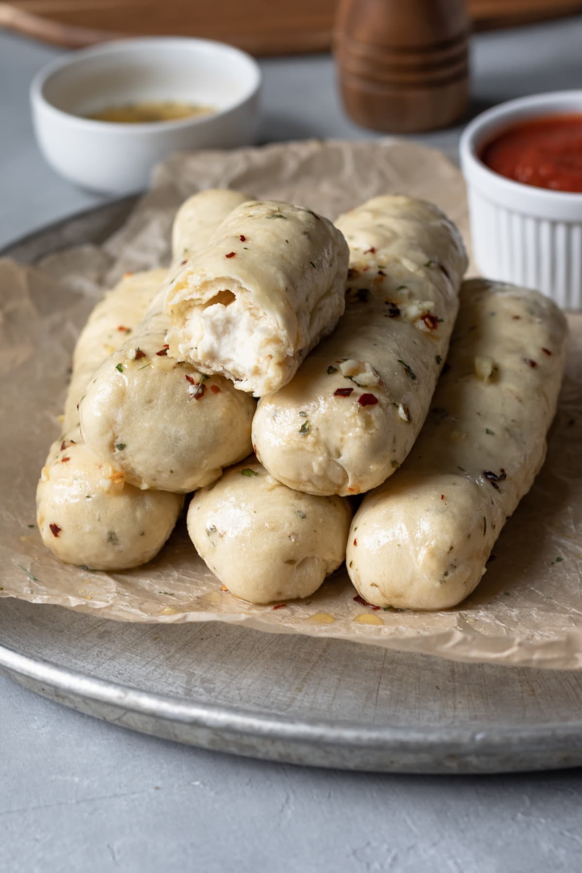 soft vegan garlic breadsticks stacked on a platter.