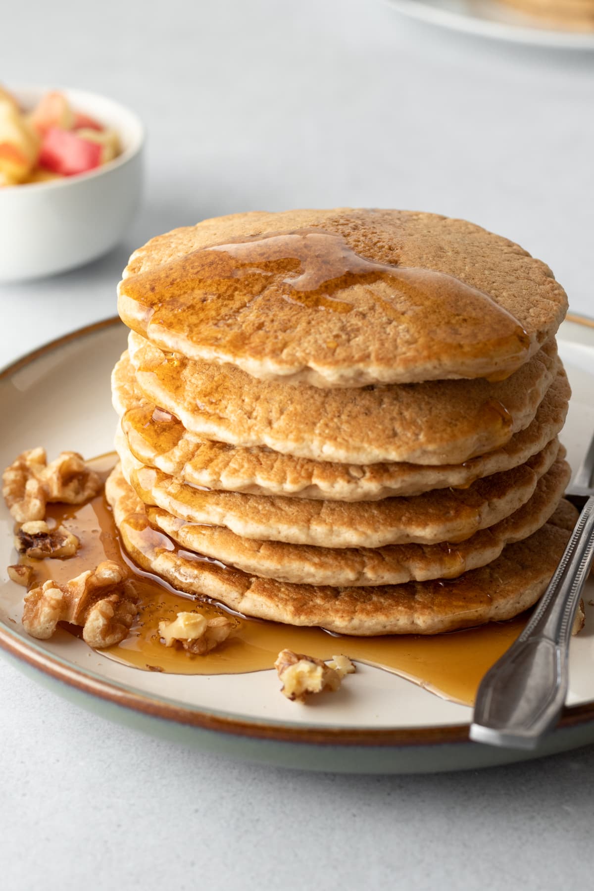 a stack of golden pancakes drizzled with maple syrup.