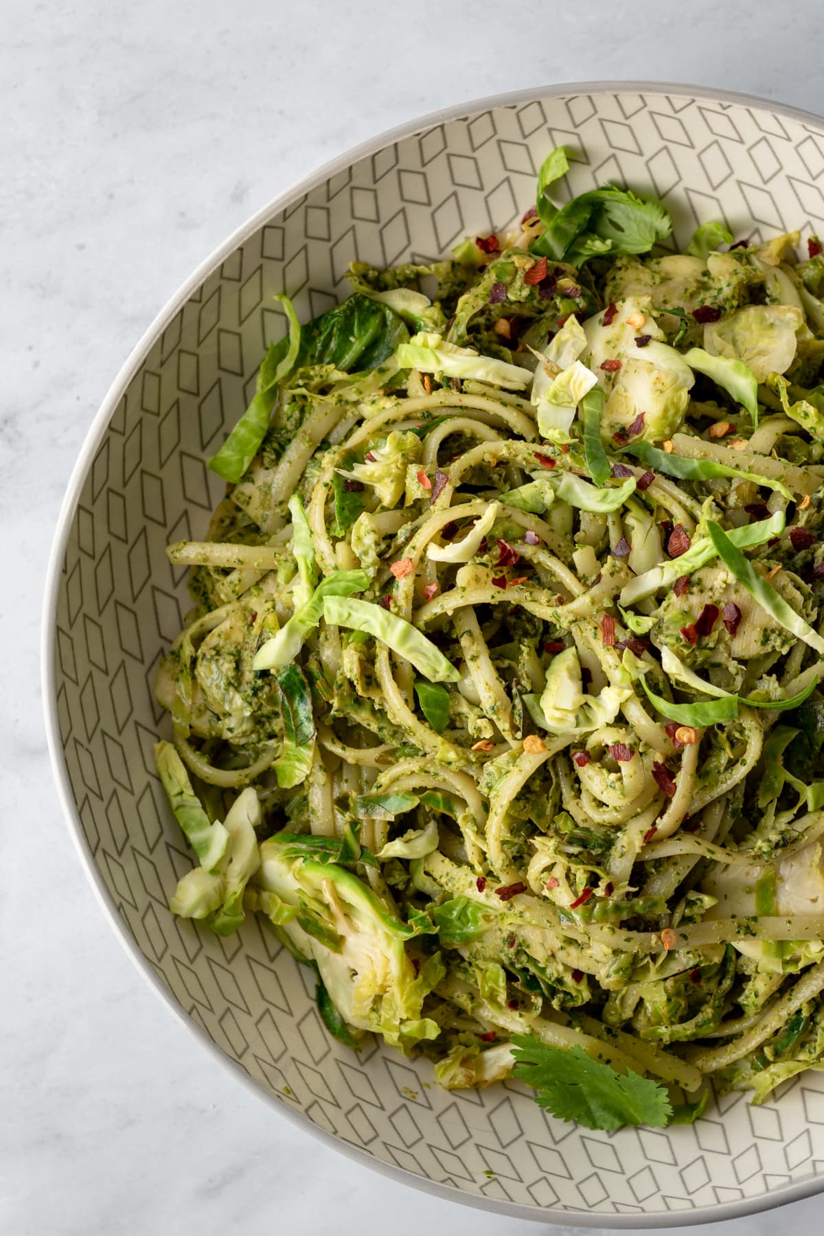 overhead close up of zhoug brussels sprouts pasta in a bowl.