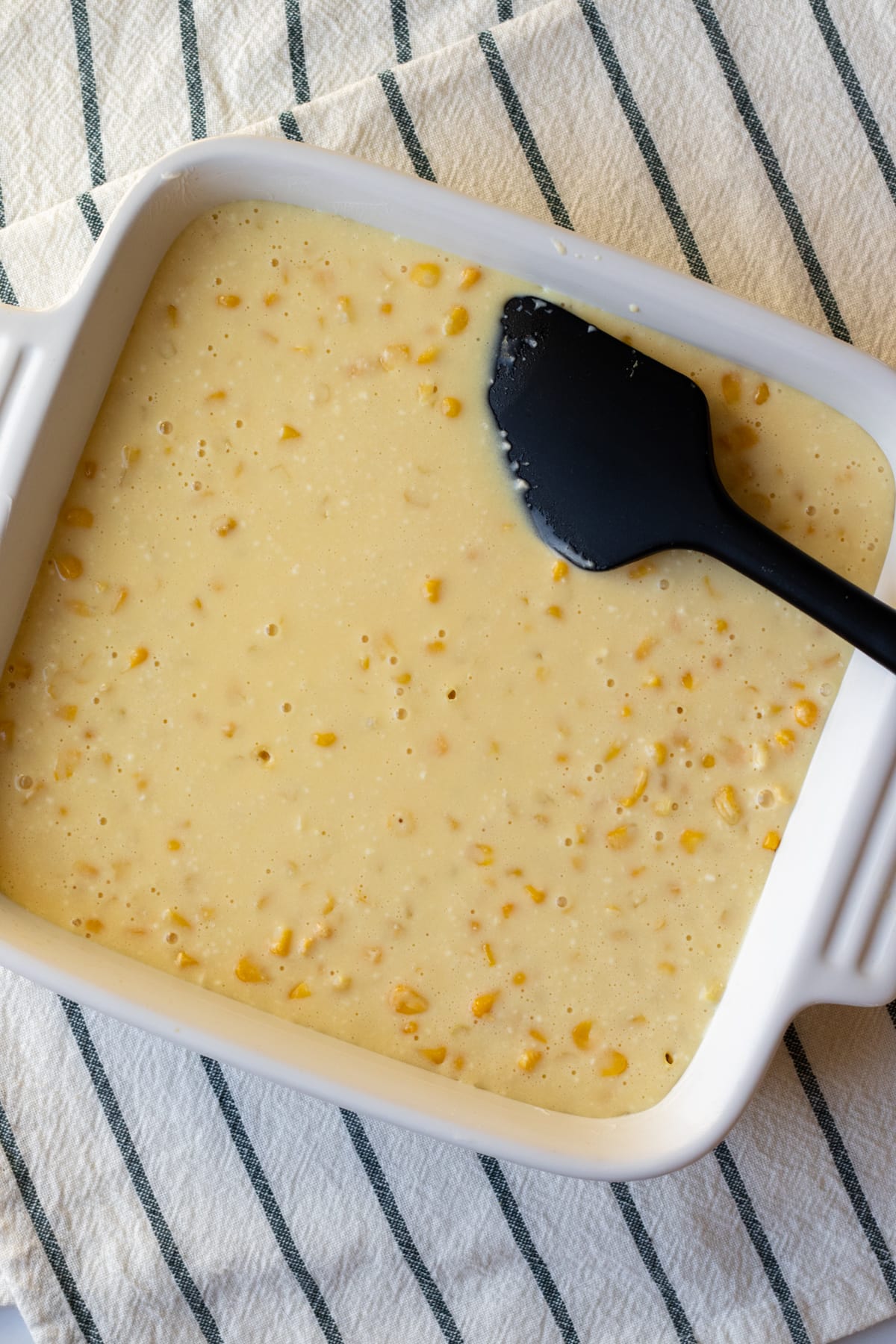 The corn casserole mixture added to a dish ready to be baked.