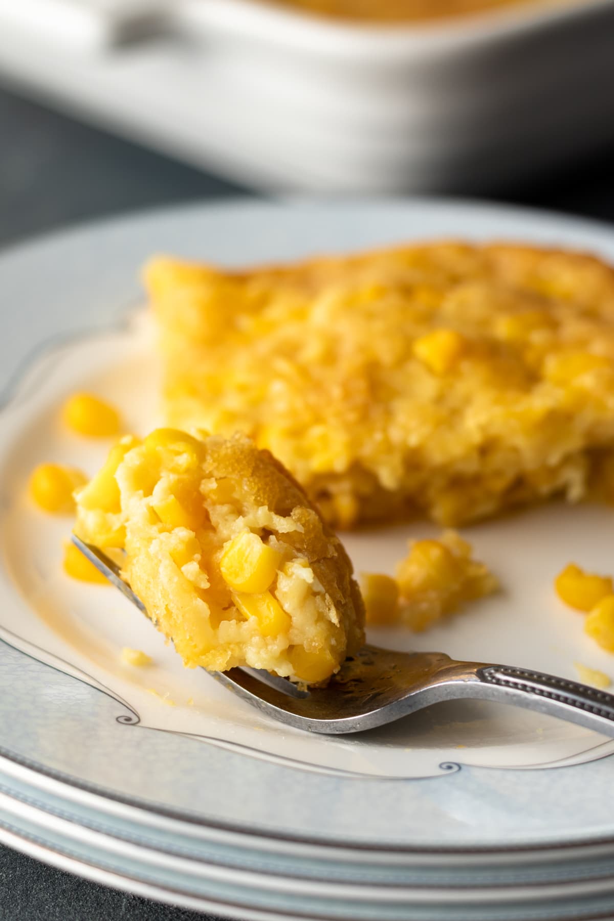 A bite of corn pudding on a fork.