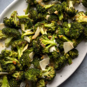 roasted broccoli on a serving platter tossed with vegan parmesan