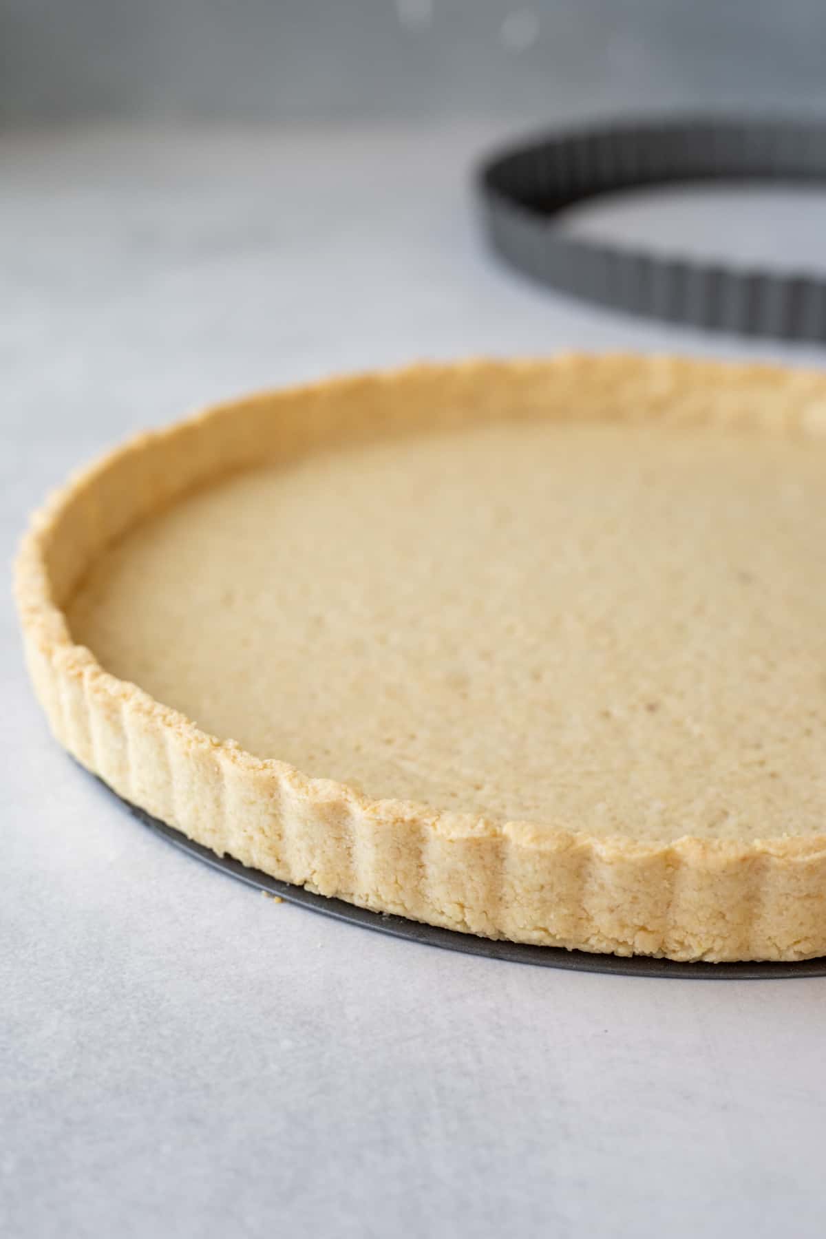 baked almond flour crust with pan ring removed to show flaky texture of crust