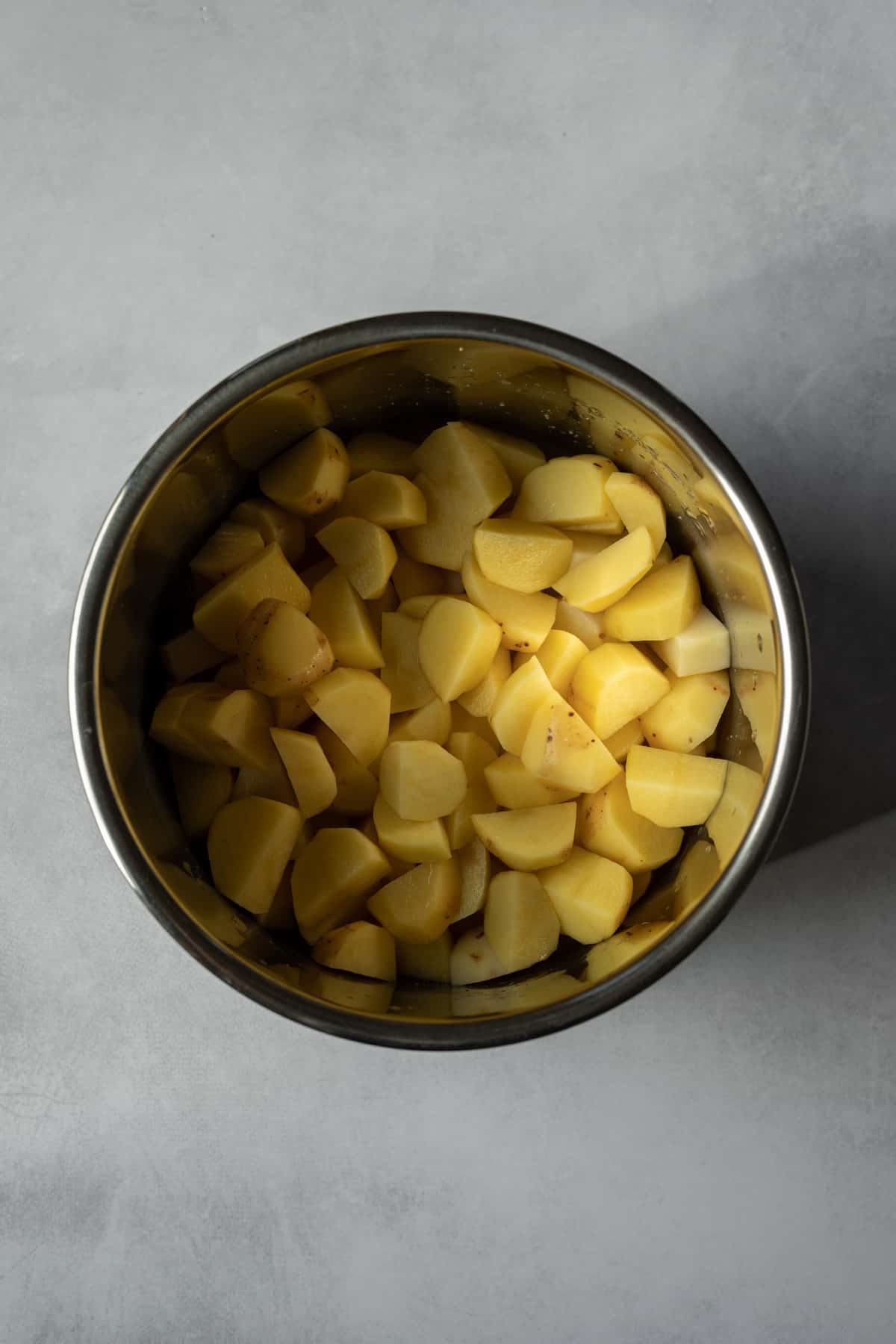 Peeled and cut Yukon gold potatoes in a pot.