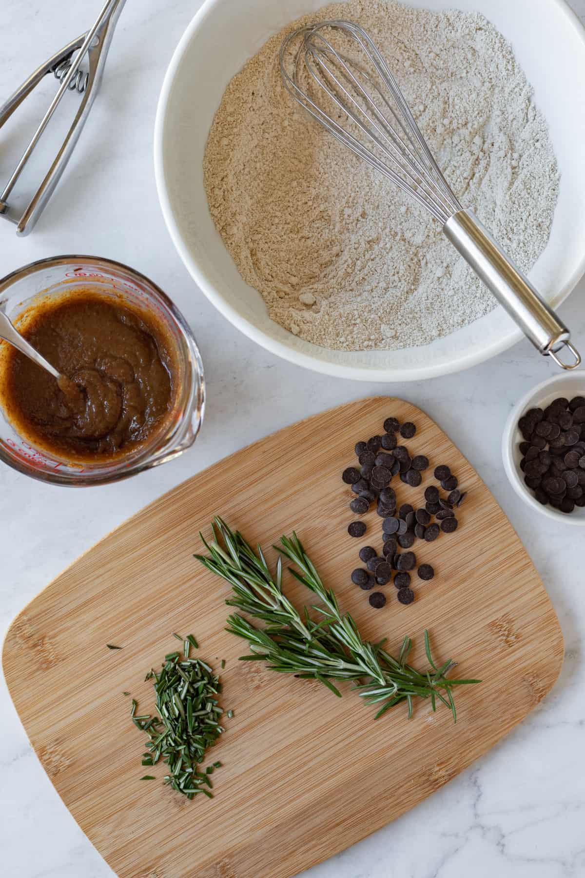 chopping rosemary and showing wet and dry ingredients in separate bowls