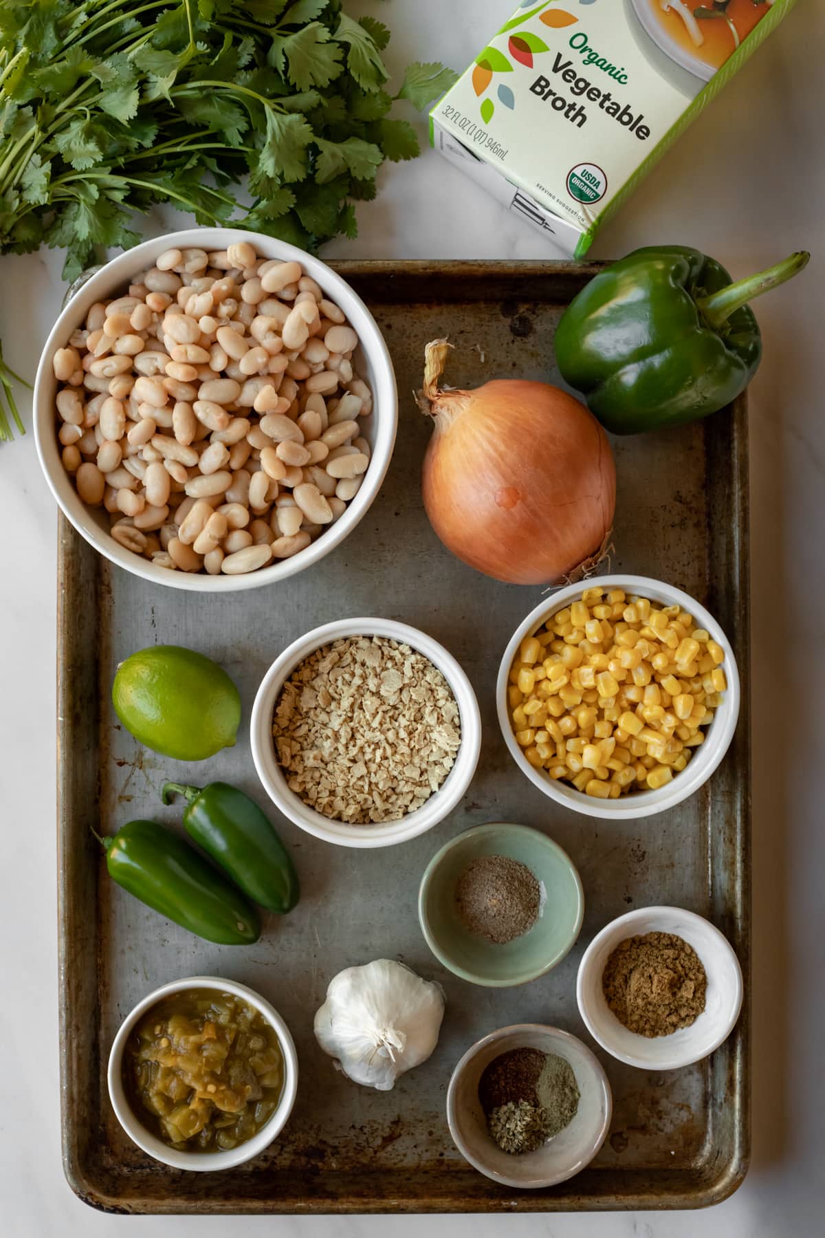 ingredients needed for white chili laid out on a large baking sheet.