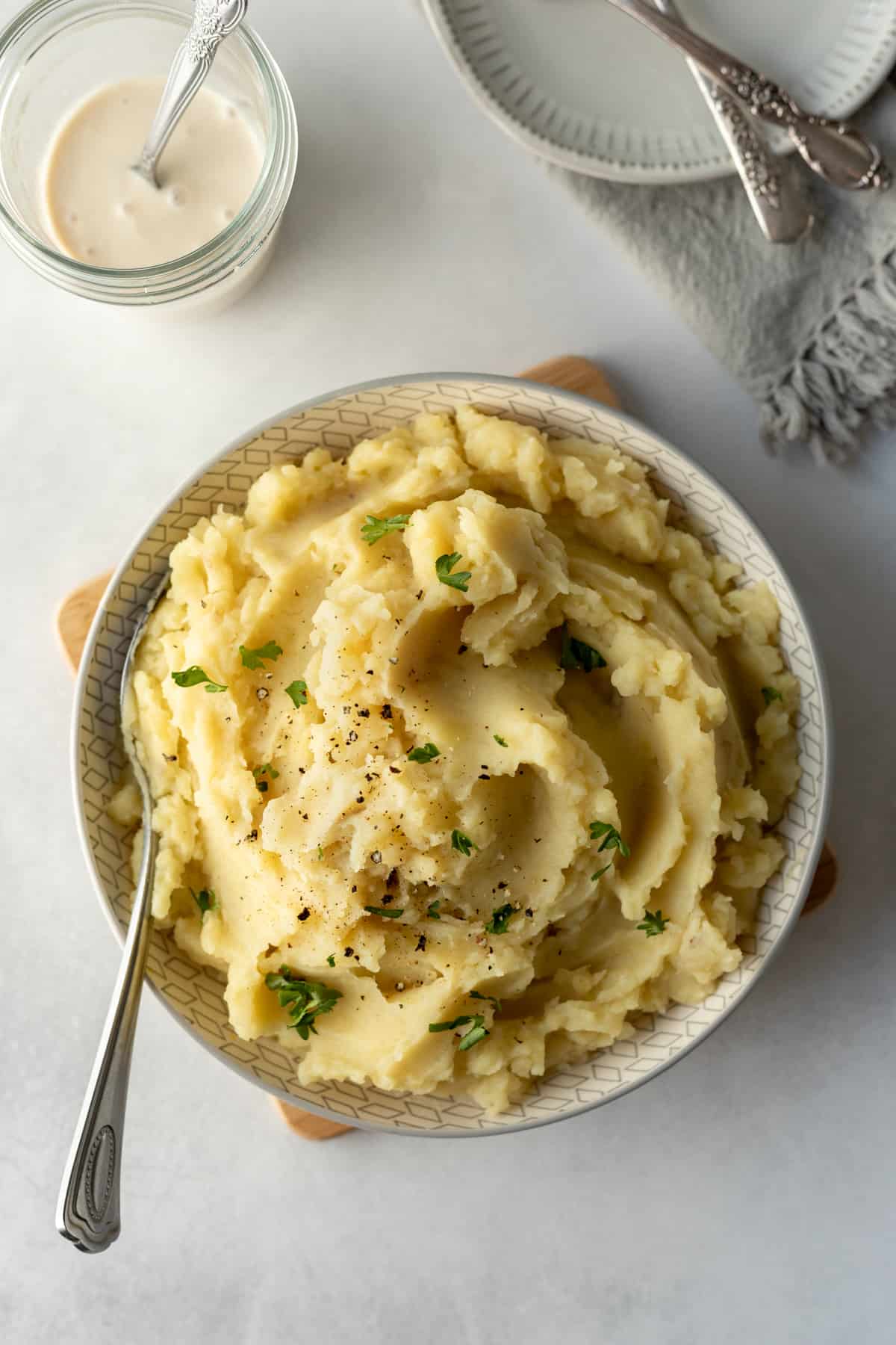 serving bowl full of creamy, golden vegan mashed potatoes.
