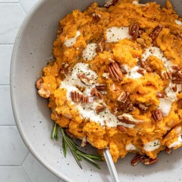 creamy sweet potato mash in a bowl with pecans and yogurt